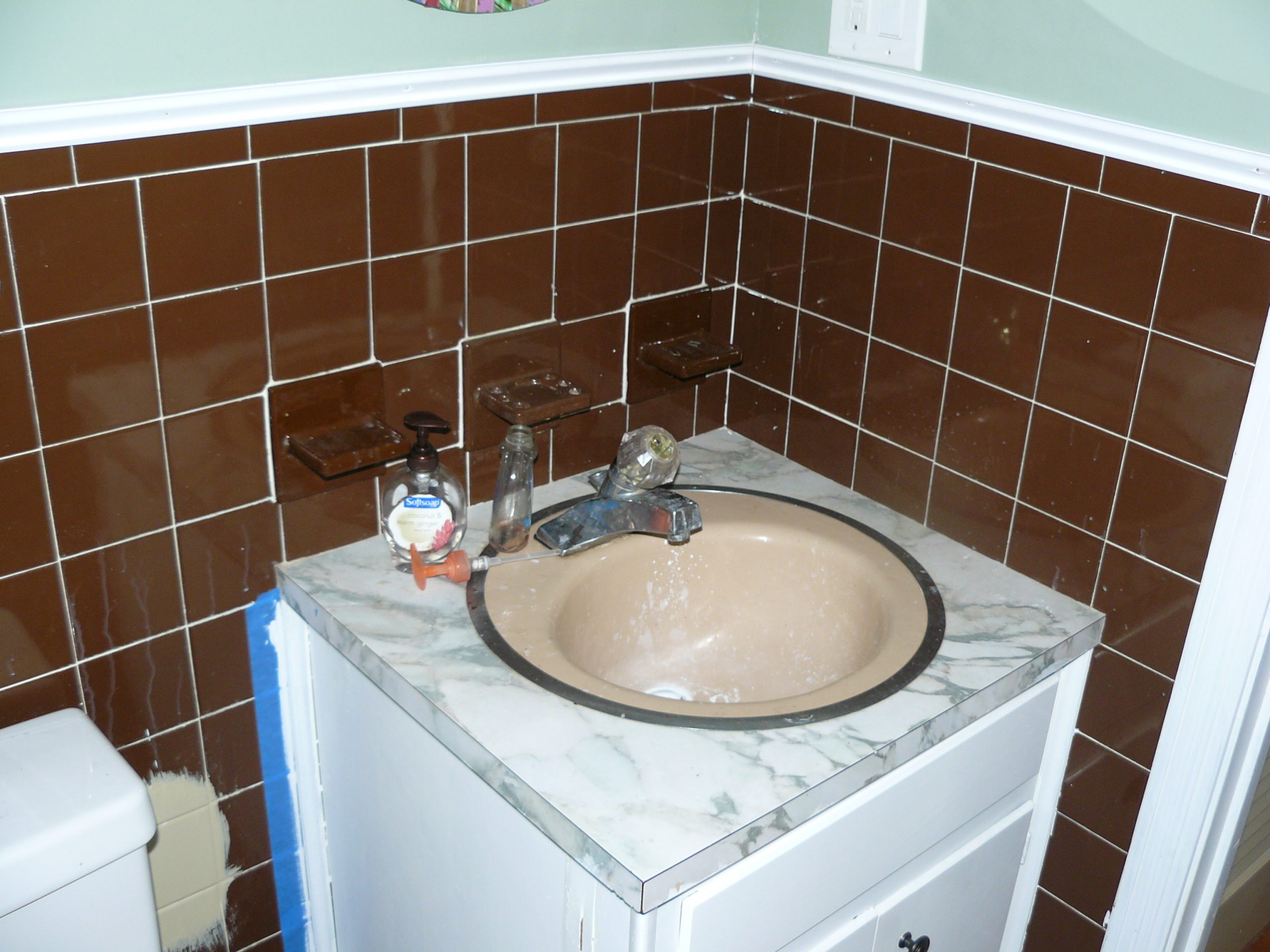 Bathroom showing old sink and old brown tiles before renovated