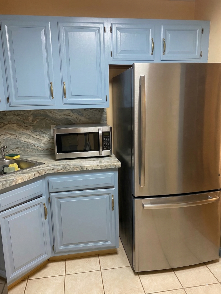 Newly installed kitchen cabinets, showing paint job with baby blue paint